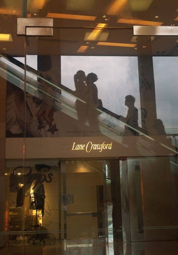 Shoppers viewed through a window of the Lane Crawford store in Hong Kong