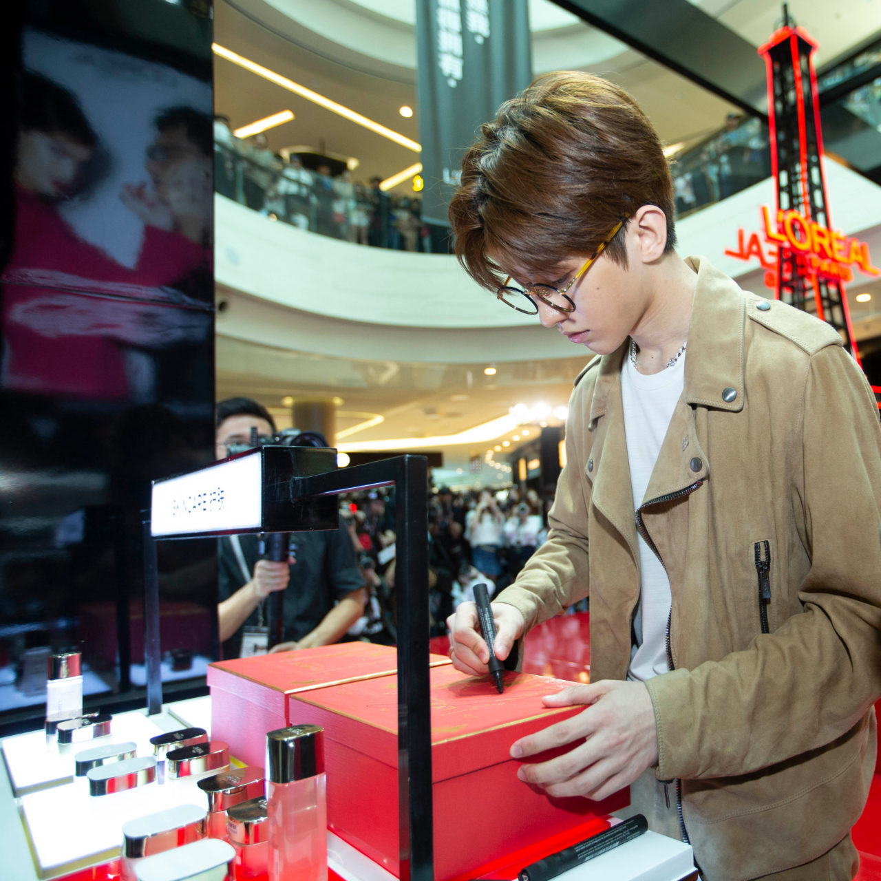 Kun signing on LOreal Paris gift box for fans scaled
